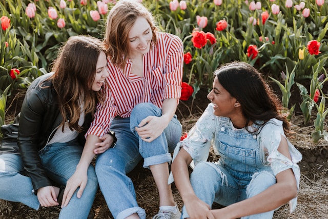 3 ladies laughing sitting down on earth