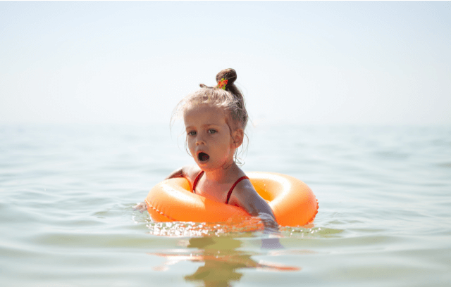 A little girl in a floater in water