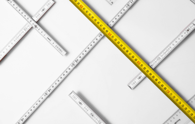 Several measuring tapes spread across a white sheet